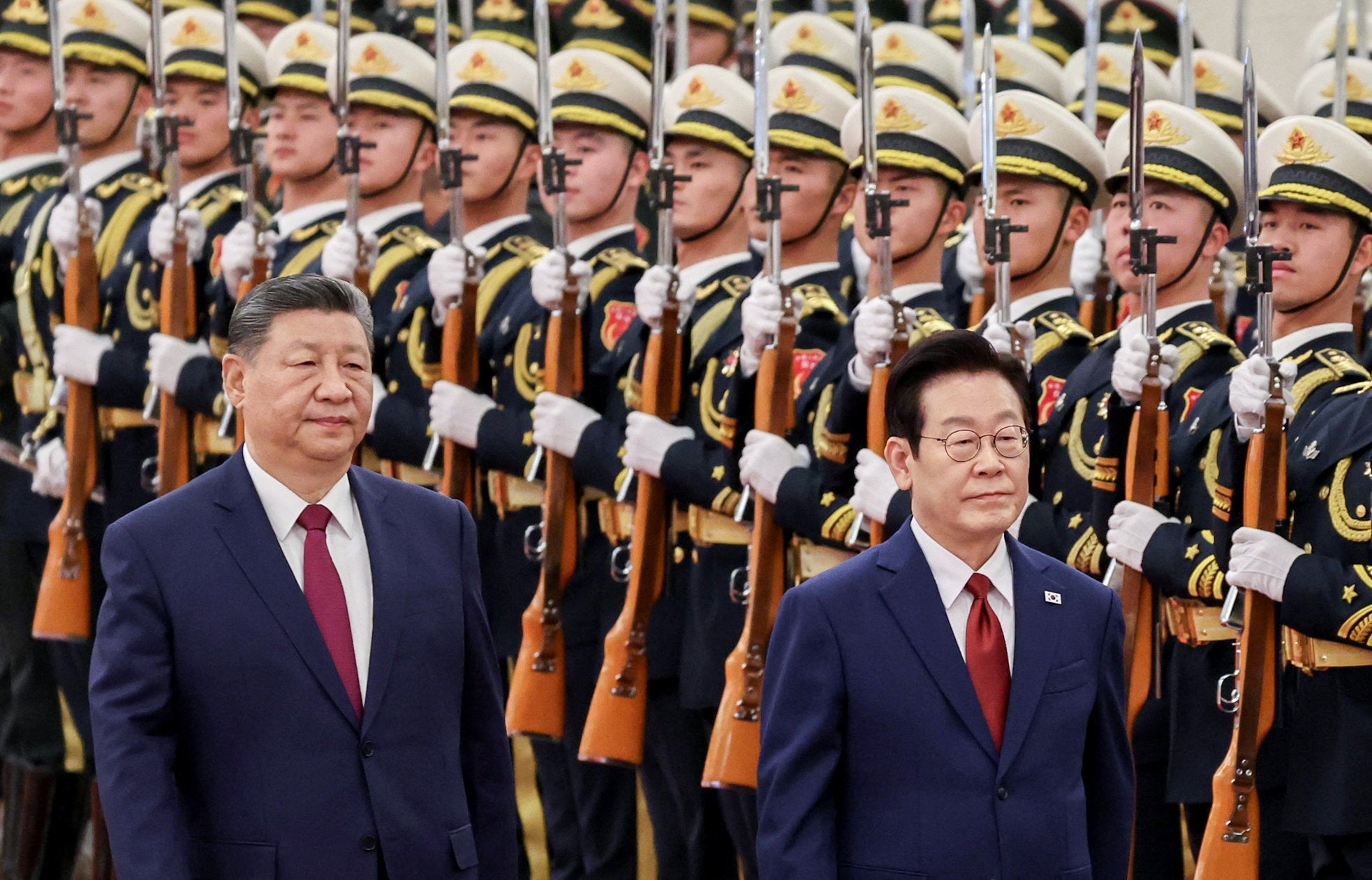 Chinese President Xi Jinping and South Korean President Lee Jae Myung inspect honor guards during a welcome ceremony at the Great Hall of the People in Beijing