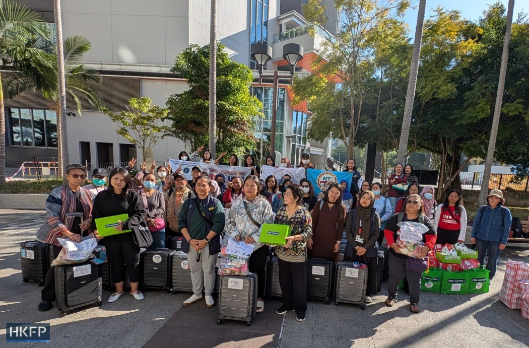 Sringatin (front, third from left), leader of the Network of Indonesian Migrant Workers (JBMI); Edwina Antonio (front, fifth from left), executive director of Bethune House Migrant Women’s Refuge; and Cynthia Abdon-Tellez (front left), general manager of the Mission for Migrant Workers (MFMW) pose with Indonesian migrant workers affected by the Wang Fuk Court fire after distributing suitcases, shoes, and care packs on December 21, 2025, in Tai Po. Photo: Yenni Kwok/HKFP.
