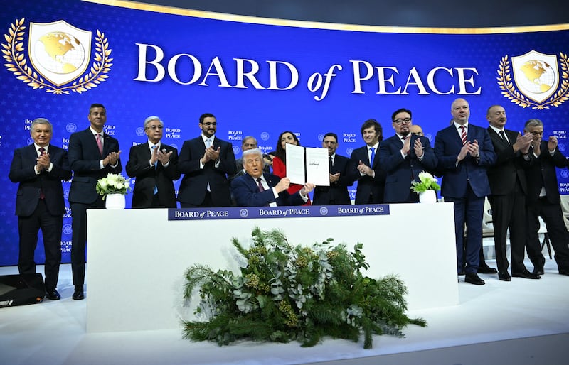 President Trump holds up his "Board of Peace" charcter surrounded mostly by strongmen and leaders from smaller countries.
