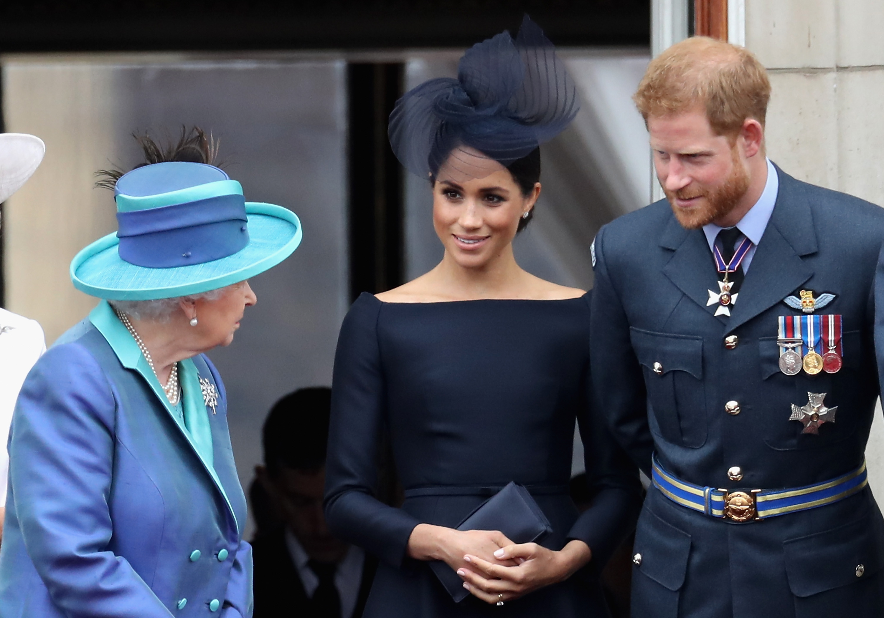 Queen Elizabeth, Meghan Markle and Prince Harry on the balcony of Buckingham Palace in 2018 wearing blue