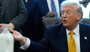 President Donald Trump gestures to a container of milk before he signs a bill that returns whole mi...