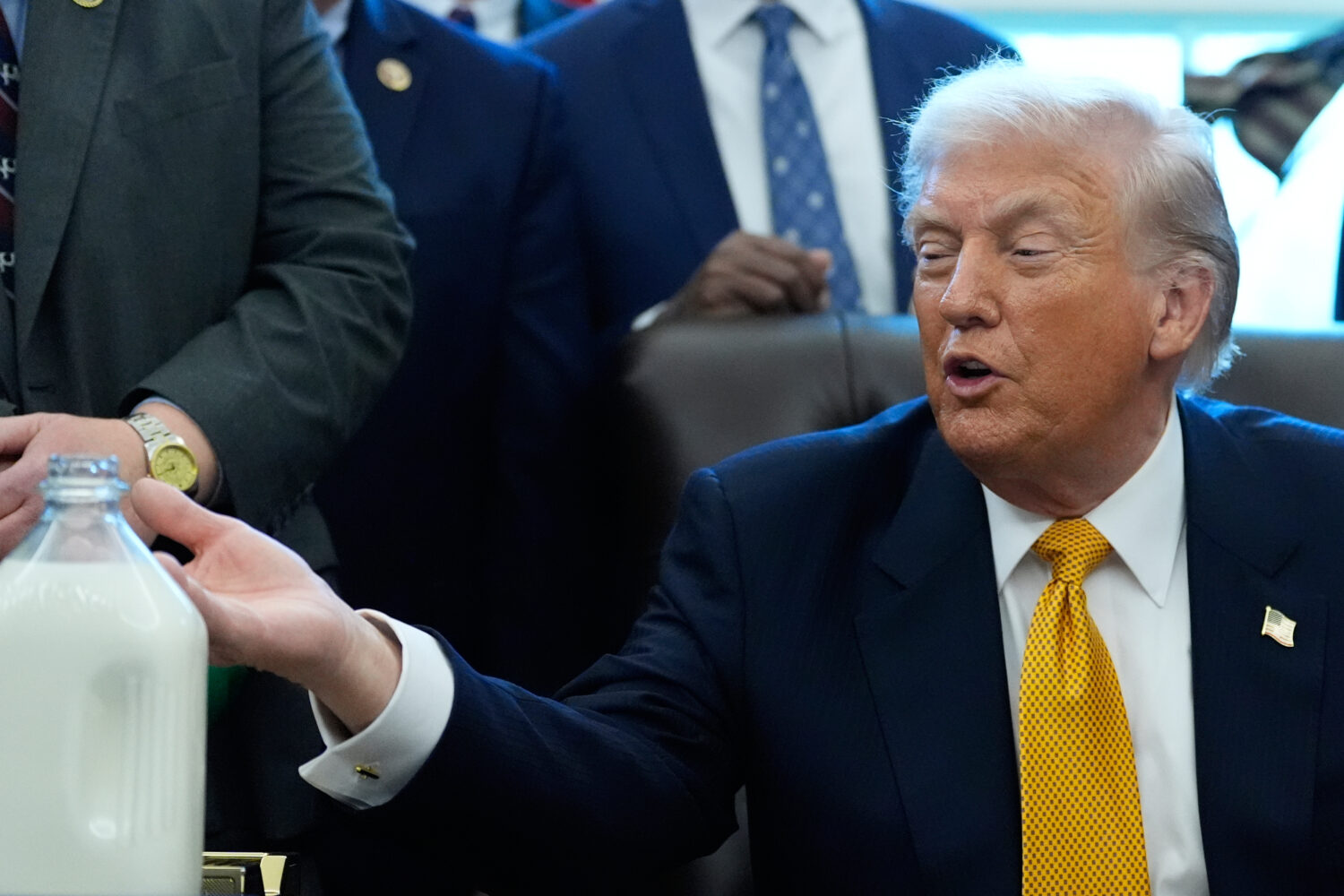 President Donald Trump gestures to a container of milk before he signs a bill that returns whole mi...
