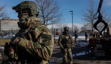 U.S. Immigration and Customs Enforcement (ICE) agents stand guard during protests against increased immigration enforcement and the fatal shooting of Renee Nicole Good by an ICE agent, in Minneapolis, Minnesota, U.S., January 9, 2026. REUTERS/Tyrone Siu