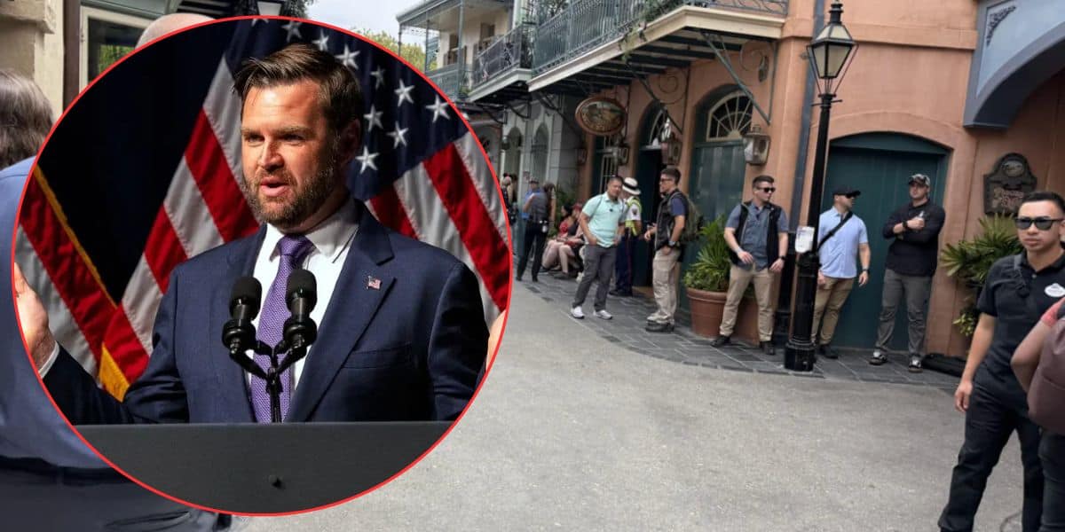 A man in a suit speaks at a podium with microphones and US flags behind him; inset in the corner of an image showing several people standing and waiting along a street lined with buildings.