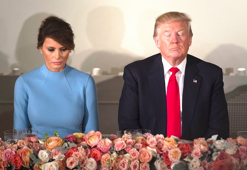 US President Donald Trump and First Lady Melania Trump pray
