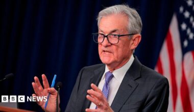Jerome Powell seen speaking at a podium. He is motioning with his hands