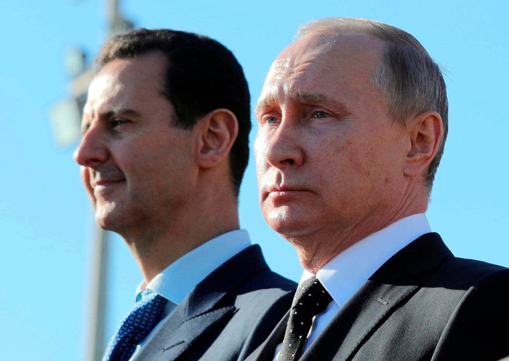 Putin and former Syrian president Bashar al-Assad watch troops at an airbase in Syria in December 2017. Photo: AP Putin and former Syrian president Bashar al-Assad watch troops at an airbase in Syria in December 2017. Photo: AP