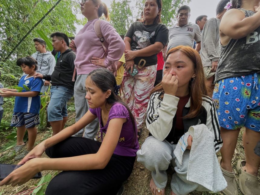 Relatives and others wait for updates after a huge mound of garbage collapsed at a waste segregation facility in Binaliw, Cebu City, on January 9, 2026.