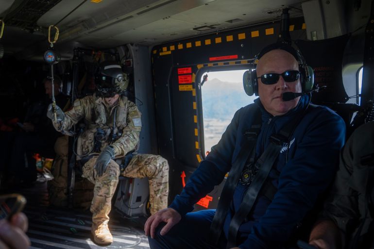 New Zealand Prime Minister Christopher Luxon, right, flies on a helicopter on Friday, Jan. 23, 2026, to view the damage from a landslide at Mount Maunganui. (Corey Fleming/Pool Photo via AP)