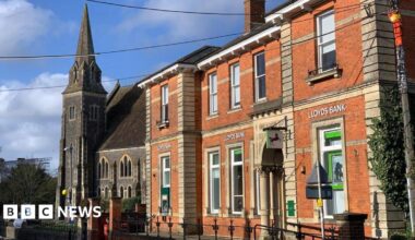Lloyds Bank in Gillingham was housed in an older two-storey red brick building with large windows and an ornate pillar on the side.