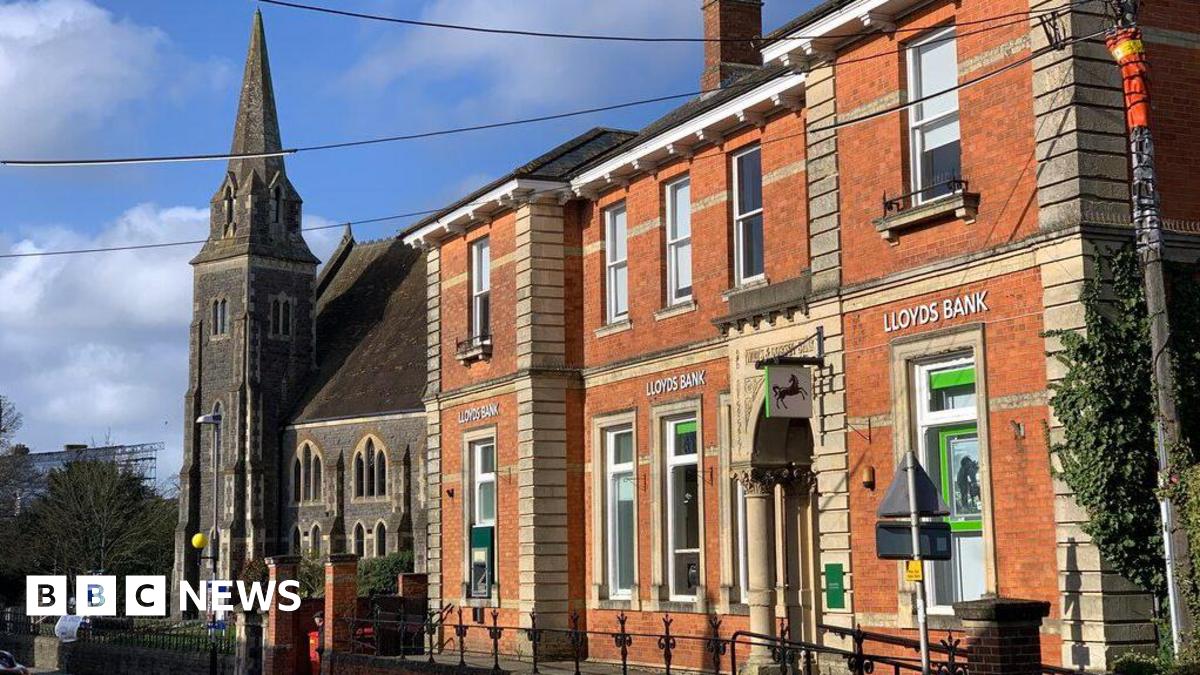 Lloyds Bank in Gillingham was housed in an older two-storey red brick building with large windows and an ornate pillar on the side.