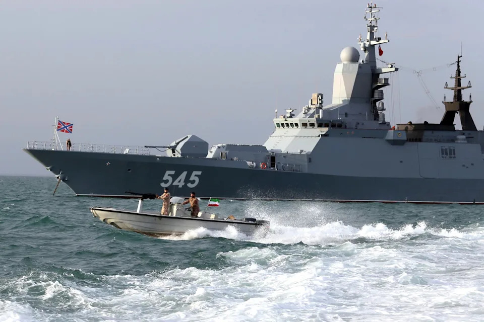 A Russian warship and an Iranian army speed boat attend a joint naval exercise on Tuesday. (AP/Iranian Army)