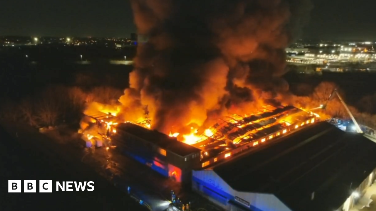 An aerial image of a large building on fire with glowing orange flames