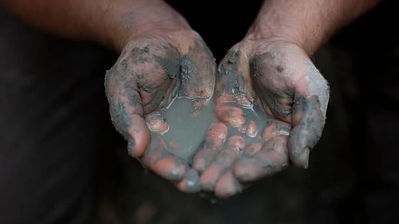 Oszkár Nagyapáti, farmer and member of the volunteer water guardians group, holds water in his hands in Kiskunmajsa, Hungary, 29 July 2025. 
