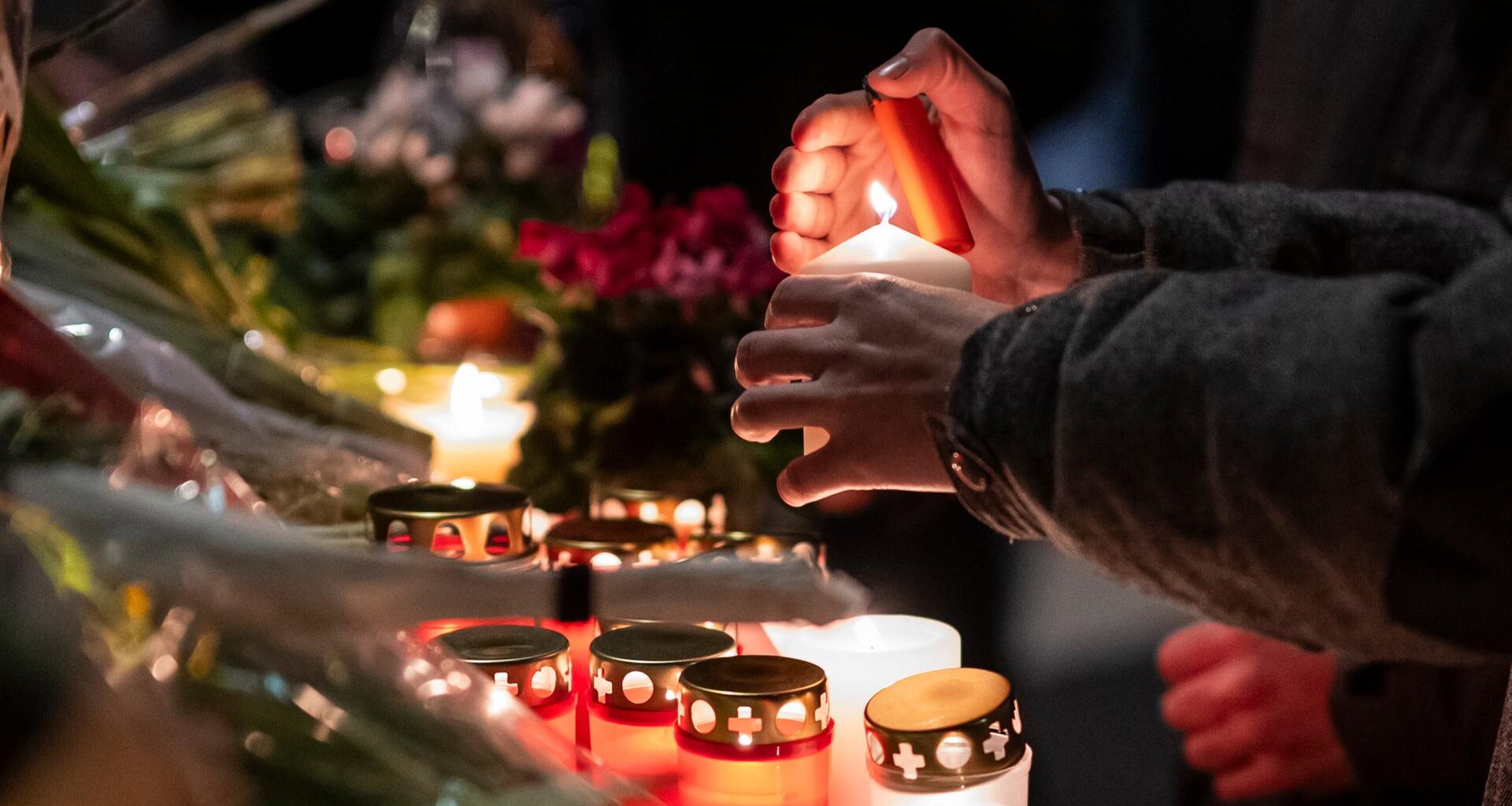 Trauerkerzen werden vor dem Unglücksort in Crans-Montana angezündet