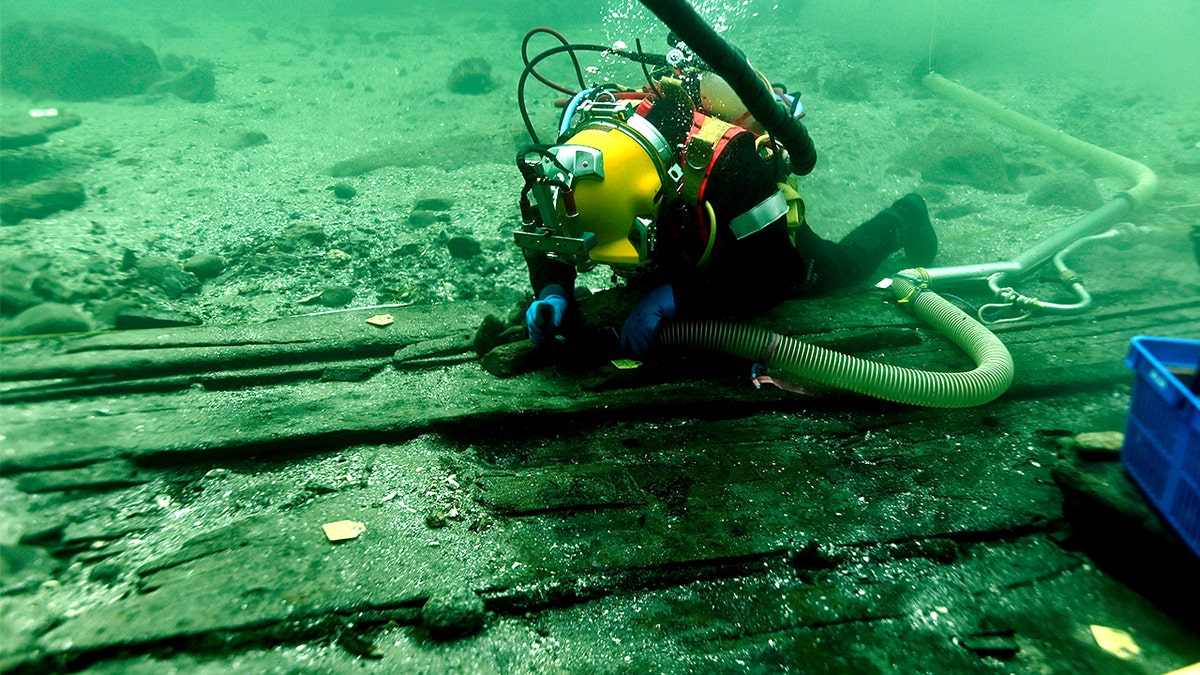 Diver analyzing medieval cog ship