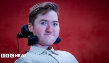 Sian Kennedy, who has long blonde hair, holding her little girl Sienna. Both are smiling at the camera.