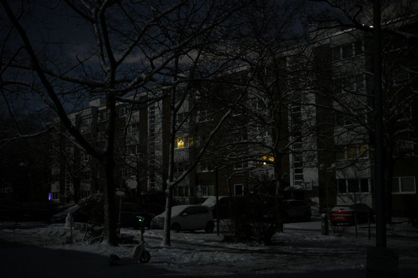 Some battery-operated Christmas decorations are seen in windows of a residential building in the Zehlendorf district on Sunday morning amid a power blackout.