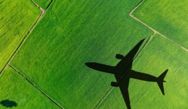 airplane flying over greens fields