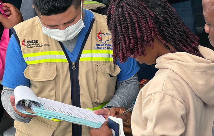Yilmer Duarte (left), with the United Methodist clinic, helps a migrant seeking health services at the Irregular Migrant Assistance Center in Danlí, Honduras. Photo by the Rev. Gustavo Vásquez, UM News.