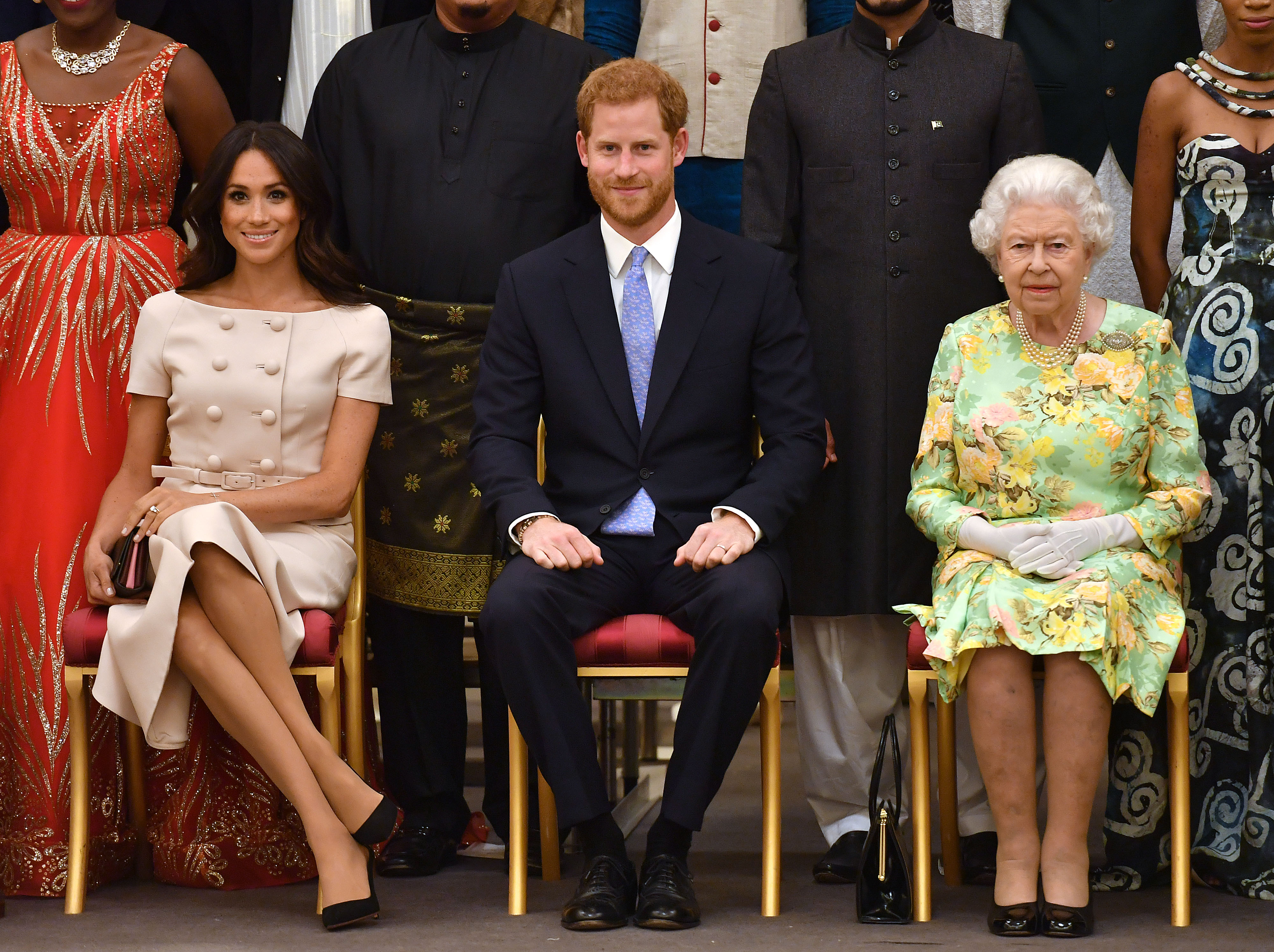 Queen Elizabeth sitting next to Prince Harry and Meghan Markle in chairs