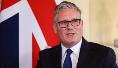 Keir Starmer speaking, seated in front of a large union jack flag