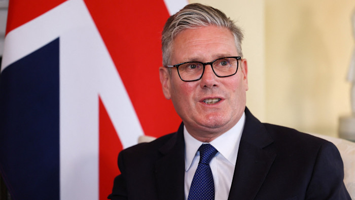 Keir Starmer speaking, seated in front of a large union jack flag