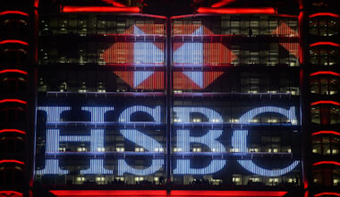 The illuminated HSBC logo is displayed at night on the facade of the HSBC headquarters building in Hong Kong.