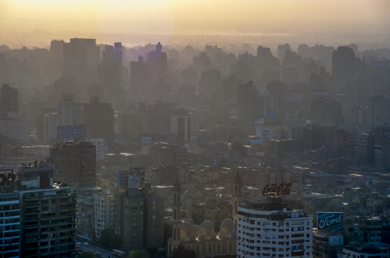 scanned historical colour photo of downtown Cairo with houses in the haze and backlighting
