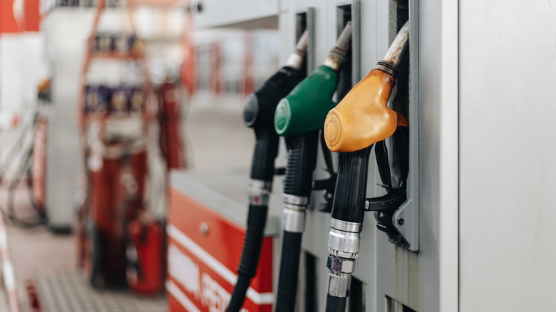 colorful array of gas pump nozzles waiting to be use at a gas station