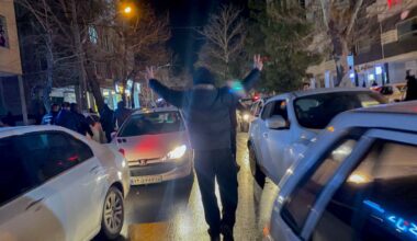 A protester flashes victory signs as traffic slows during demonstrations in Hamedan, Iran, on January 1, 2026.