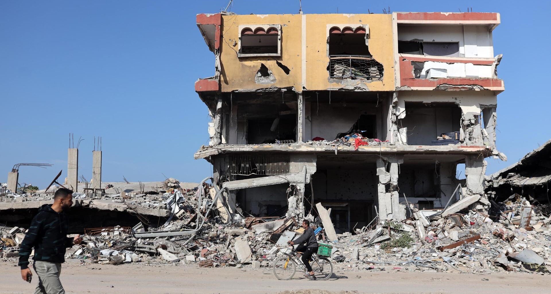 Menschen gehen an einem völlig zerstörten Haus in Gaza-Stadt vorbei.