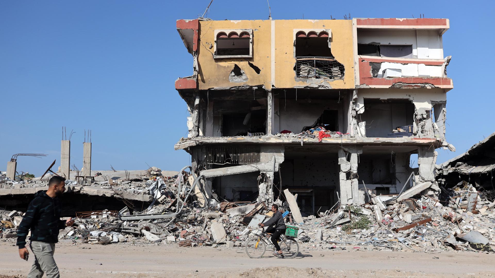 Menschen gehen an einem völlig zerstörten Haus in Gaza-Stadt vorbei.