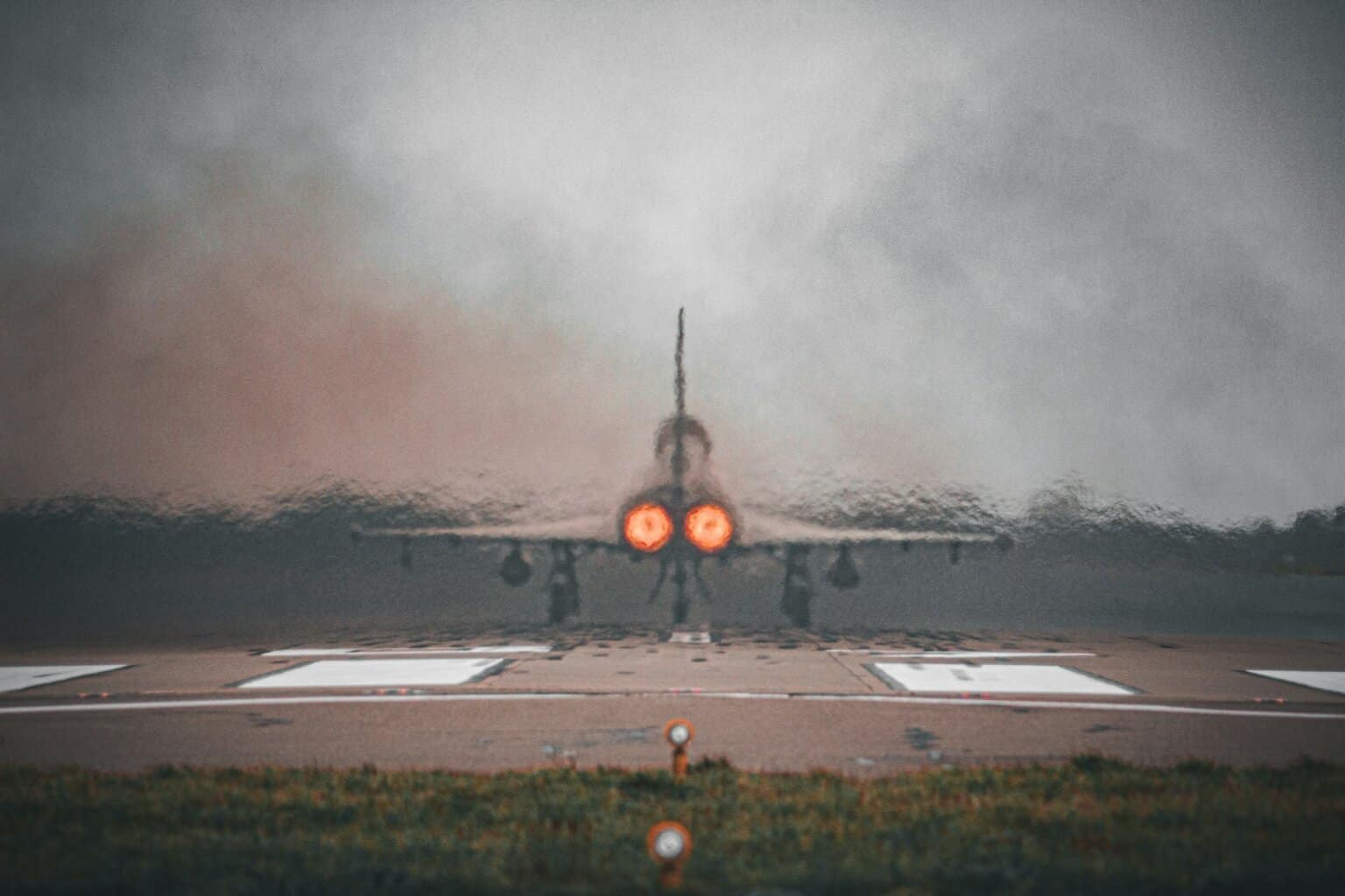 a fighter jet sitting on top of an airport runway