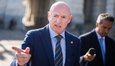 Sen. Mark Kelly talks with reporters outside the Capitol on Jan. 8 after a vote on the war powers resolution.