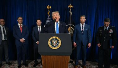 Trump spricht hinter einem Rednerpult. Hinter ihm stehen Mitglieder der US-Regierung.