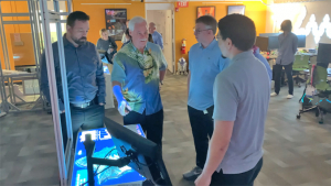 people gather around a monitor