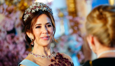 Queen Mary wearing a diamond and ruby tiara and a matching necklace with an embroidered red gown
