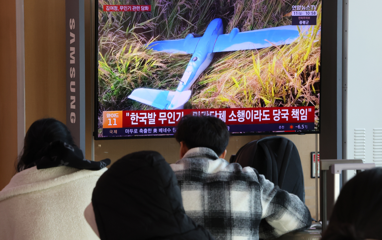 South Korean citizens watch news coverage at Seoul Station on Sunday regarding North Korea’s claim that South Korean drones violated its airspace. (Yonhap)