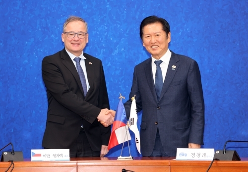 Democratic Party leader Jung Chung-rae (right) shakes hands with Czech Ambassador to Korea Ivan Jancarek at the Party Leaders Meeting Room in the National Assembly on Tuesday. (Yonhap)
