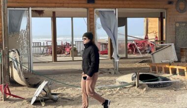 Une femme passe devant des débris dans une rue de Praia da Vieira, à Leiria, après le passage de la tempête Kristin au Portugal, le 29 janvier 2026.