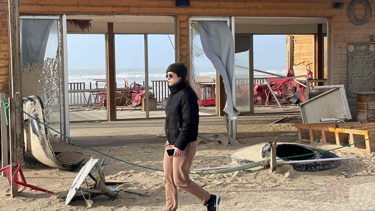 Une femme passe devant des débris dans une rue de Praia da Vieira, à Leiria, après le passage de la tempête Kristin au Portugal, le 29 janvier 2026.