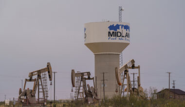 A water pipeline from the T-Bar Ranch terminates at this water tower on the western side of Midland, Texas, where oil pump jacks operate. Credit: Paul Ratje/Inside Climate News