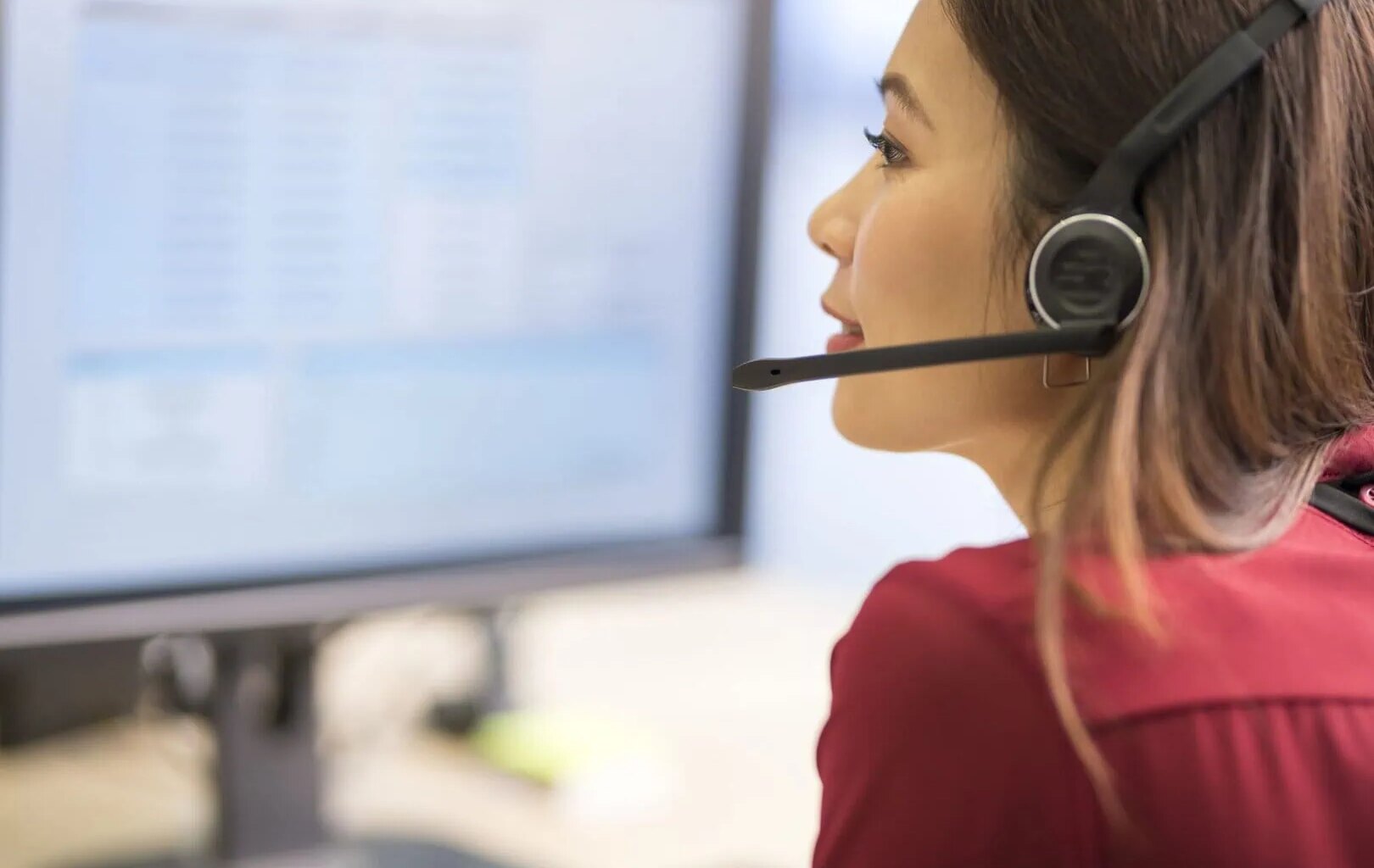 Close-up of customer service representative wearing wireless headset working in call centre.