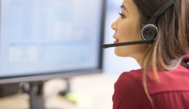 Close-up of customer service representative wearing wireless headset working in call centre.