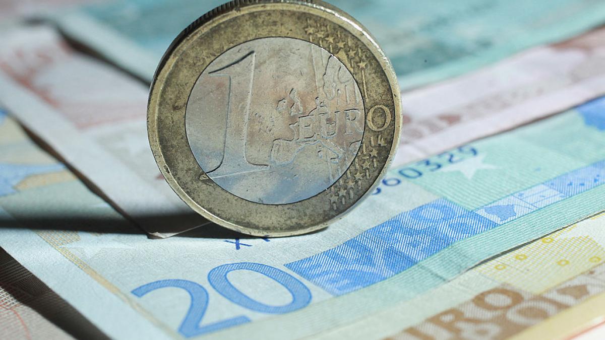 monedă euro pe bancnote euro