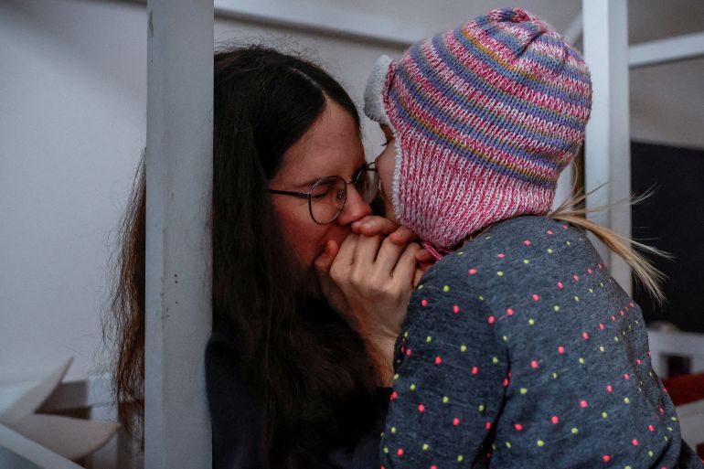 FILE PHOTO: Yuliia Chumak, 32, who is eight months pregnant, warms her three-year-old daughter Kvitoslava's hands with her breath, as they get ready to leave for the kindergarten in their apartment during power cuts following Russian missile and drone strikes, in Kyiv, Ukraine, January 14, 2026. REUTERS/Alina Smutko/File Photo