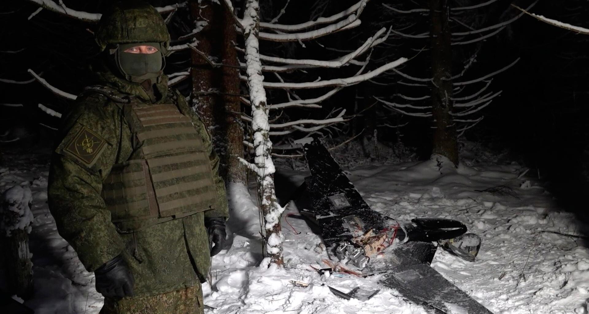 Ein Mann steht neben einer angeblich abgeschossenen ukrainischen Drohne