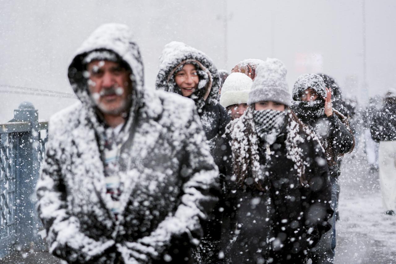 People are seen walking under heavy snowfall in the Eminonu area on Istanbul’s European side as snow continues to affect parts of the city during the first day of the New Year on Jan. 1, 2026. (AA Photo)