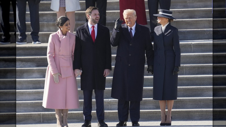 Wearing a pink coat, Usha Vance sports a wide smile in a group photo with JD Vance and the Trumps